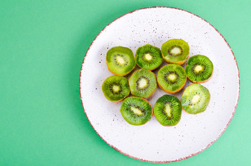 Halves of ripe sweet green kiwi on white plate