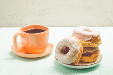 Сoffee break. Orange cup with coffee and a plate from donats