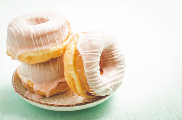 Donats in white glaze. Fresh pastries. A plate from donats in white glaze. Closeup. Sweet food concept.
