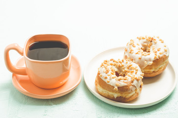 Сoffee break. Orange cup with coffee and a plate from donata in white glaze with nuts