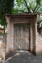 Naklejka premium Rustic Wooden Door with Brick Surrounds