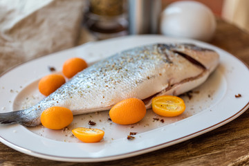 Preparation for roasting in an oven of fresh fish the Gilthead strewed with spices. Soft focus. Easy degradation. Macro.