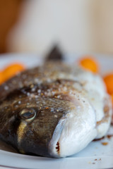 Preparation for roasting in an oven of fresh fish the Gilthead strewed with spices. Soft focus. Easy degradation. Macro.