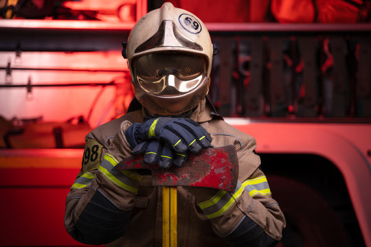 Image of man fireman in helmet and mask on background of fire truck