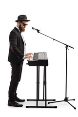 Man standing, playing a digital piano and singing on a microphone