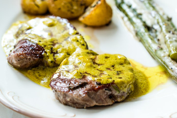 Tenderloin Meat with Cafe De Paris Sauce with Asparagus and Baked Potatoes in Plate Ready to Serve.