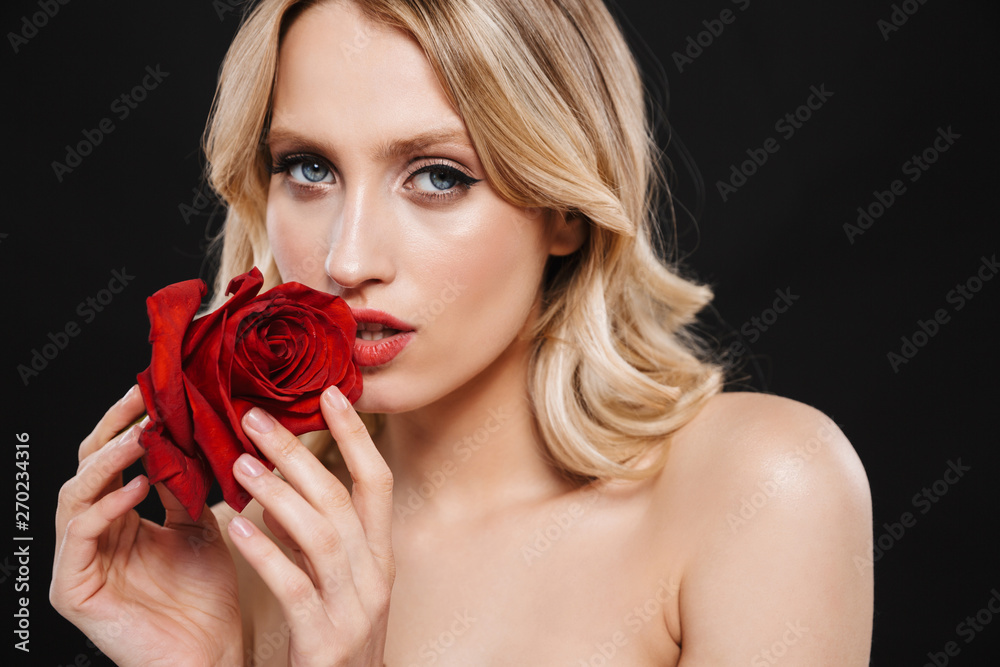 Sticker Beautiful woman with bright makeup red lips posing isolated over black background with flower.