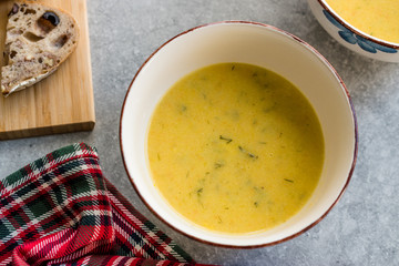 Homemade Zucchini and Carrot Soup with Crispy Bread at Lunch Table.