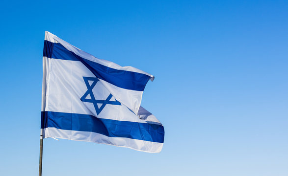 evolving in the wind  Israeli flag on blue sky background with empty copy space for text wallpaper pattern photography  