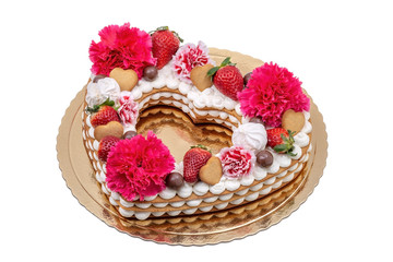 Fototapeta na wymiar Cake heart with flowers of carnations, strawberries and cookies.