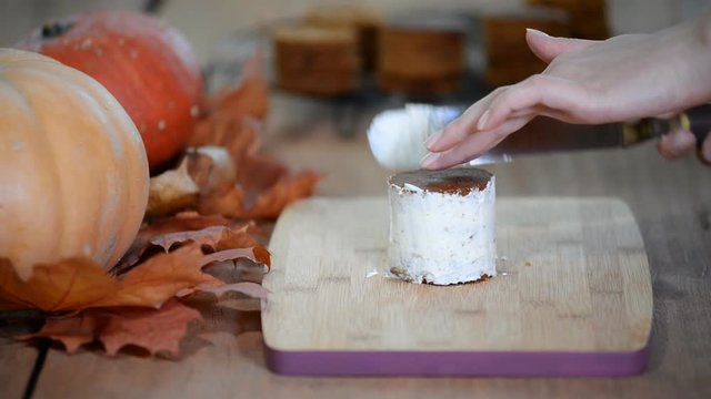 Woman in kitchen making pumpkin small cake