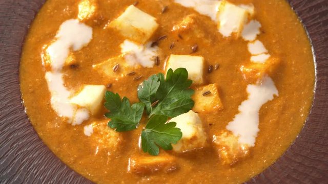 Close up of Shahi paneer Indian vegetarian masala gravy meal with vegetables, white sauce and butter paneer cottage cheese north India dish served with parsley on white background