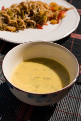 Homemade Zucchini and Carrot Soup with Crispy Bread at Lunch Table.