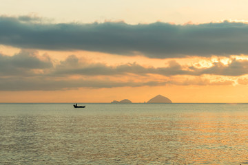 Naklejka premium Lonely fishing boat of in sea at dawn with colorful sky