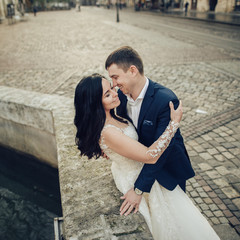 Lovely wedding couple kissing in the city.