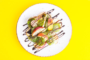 Tasty fruit salad on bright pastel background