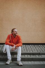 Fototapeta premium Happy smiling hipster man sitting on stairs