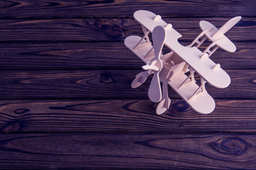 model of a wooden plane on a wooden background. air transport, travel.