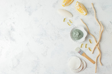 Preparing cosmetic volcanic clay mask with citrus lemon and cosmetic oil on light gray background, concept of natural organic cosmetic products for face body health care