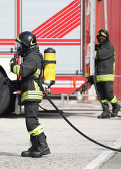 Naklejka premium firefighter with apparatus and the fire engine