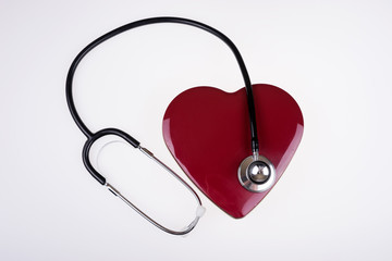 Stethoscope on a big dark red heart. Listen to heartbeat