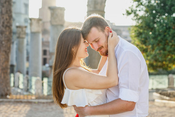 Fototapeta premium young beautiful couple in white clothes walks in Rome in Italy at sunset