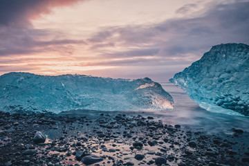 Beautiful sunrise over famous Diamond beach in Iceland. This sand lava beach is full of many giant ice chunks, placed near glacier lagoon Jökulsárlón in southeast Iceland.