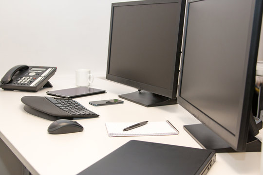 ein ergonomischer Arbeitsplatz mit ergonomischer Tastatur und zwei Bildschirmen im Büro
