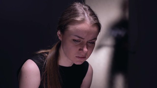Kidnapped female victim crying on camera, tyrant husband with belt outside door