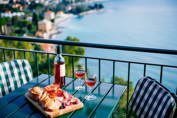 Two glasses of wine and italian snacks  with amazing view at sunset in Italy.