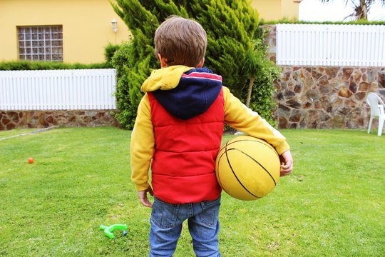 ni&ntilde;o impaciente por jugar a la pelota. Colores rojo, amarillo, azul, verde y marr&oacute;n.