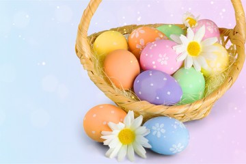 Easter basket filled with colorful eggs on a white background