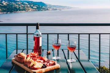 Two glasses of wine and italian snacks  with amazing view at sunset in Italy.