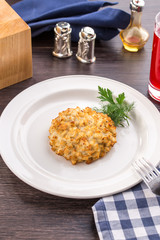 Fried pork chops in breadcrumbs on white plate on wooden table