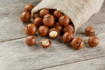 Macadamia nut on a wooden table in a bag, closeup, top view