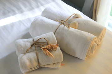 White towel decorated by seashell in hotel room