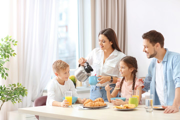 Happy family having breakfast together in kitchen - obrazy, fototapety, plakaty