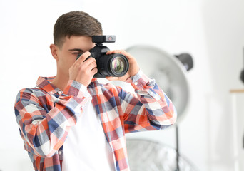 Obraz premium Young male photographer working in studio