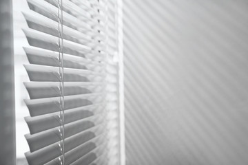 Window with closed horizontal blinds indoors. Space for text