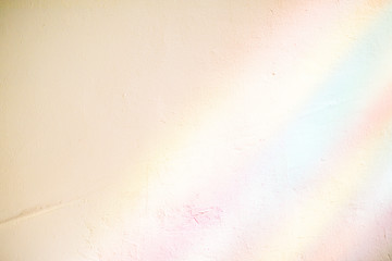 Plastered wall in the colorful sunlight rays from stained glass window