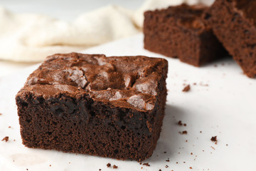 Fototapeta na wymiar Pieces of fresh brownie on white table, space for text. Delicious chocolate pie