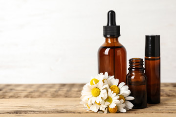 Composition with bottles of chamomile essential oil on table. Space for text