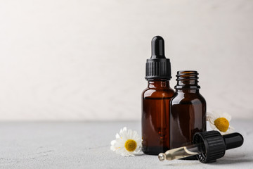 Composition with bottles of chamomile essential oil on table. Space for text