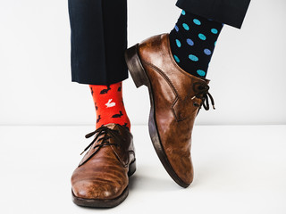 Office manager standing in stylish shoes, blue pants and bright, colorful socks on a white, isolated background. Close-up. Studio photo. Concept of lifestyle, fun and elegance