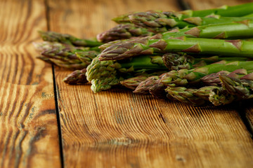 Fresh green asparagus on yellow wooden table 