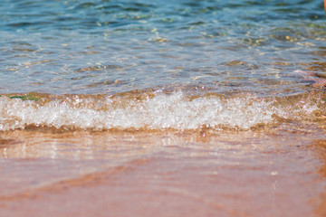 Fototapeta na wymiar Closeup photo of sea waves rolling on the sandy sea beach. bokeh background.