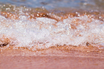Closeup photo of sea waves rolling on the sandy sea beach. bokeh background.