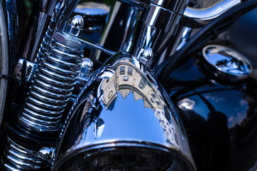 Reflection of buildings in chrome headlight of old motorcycle