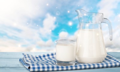 Glass of milk and jar on  background