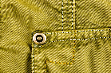 clothing items stonewashed cotton fabric texture with seams, clasps, buttons and rivets, macro